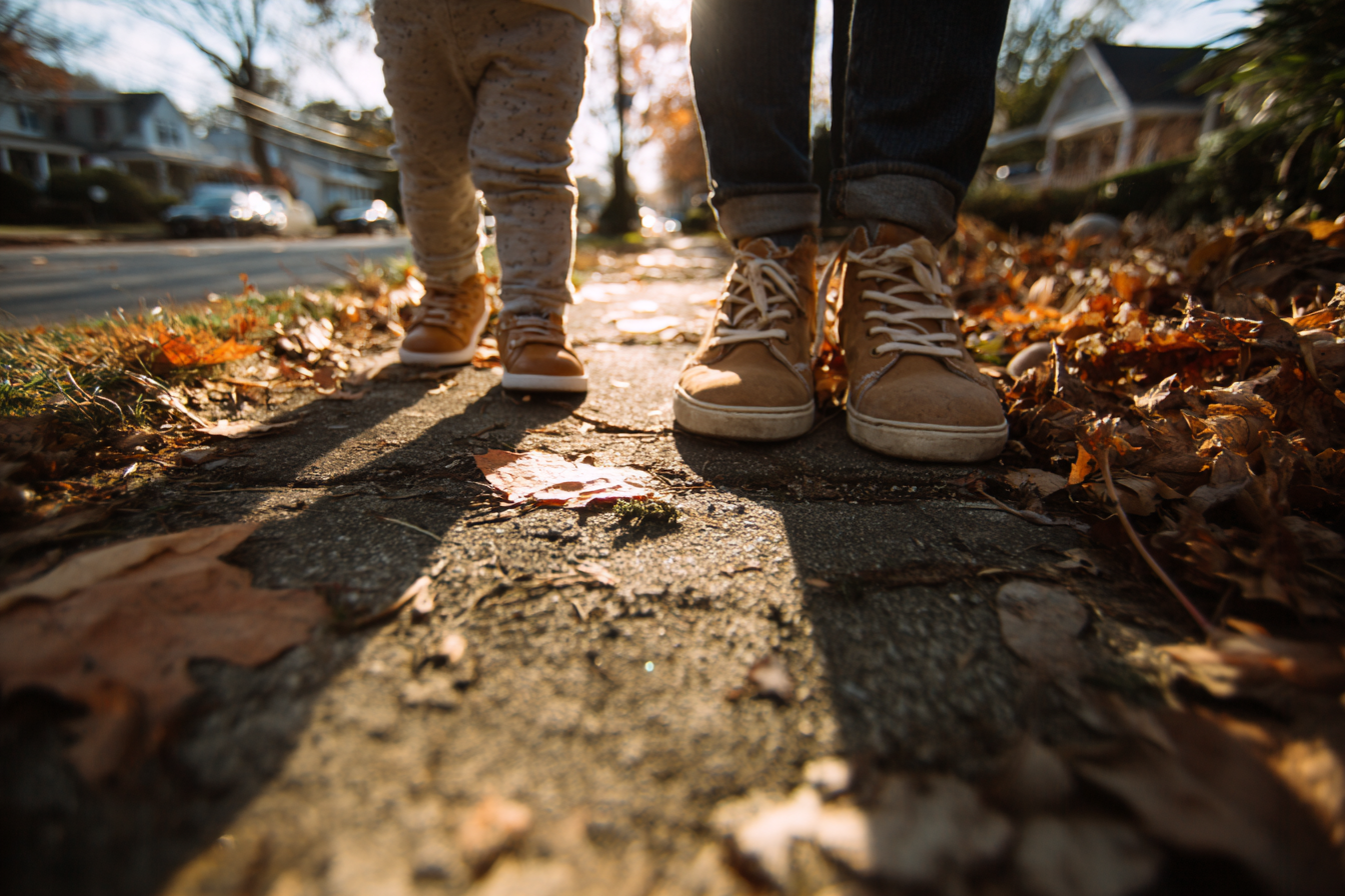 Toddler crouching outdoors and observing something tiny on the ground