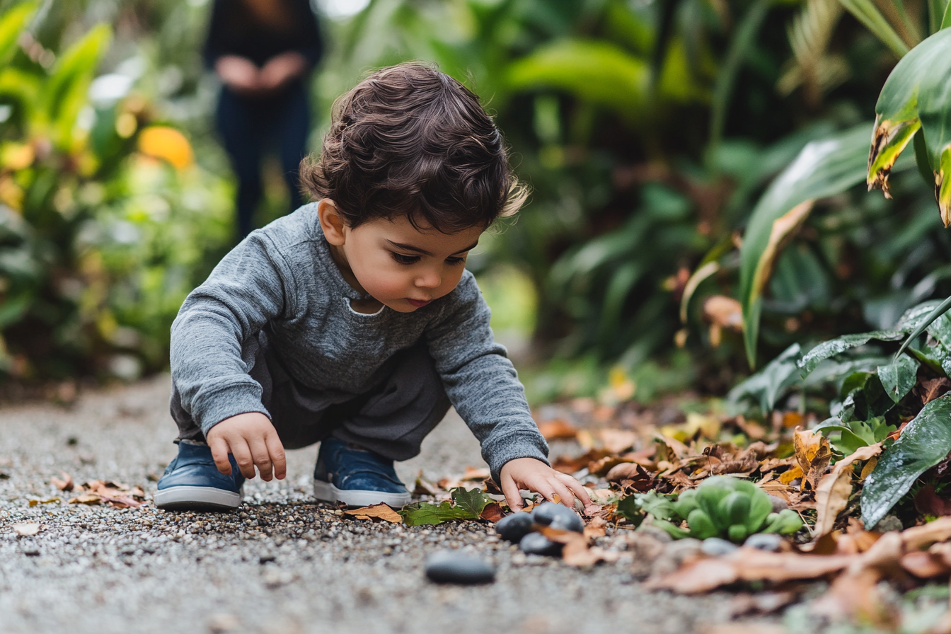Toddler safely observing leaves stones and a shallow puddle outdoors